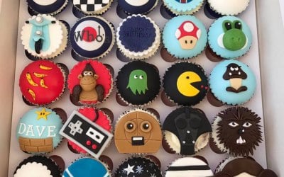 A mixed interest birthday selection of cupcakes for three members of the same family celebrating their birthdays on the same day! Featuring Mod cupcakes, Retro Games and Star Wars Designs!