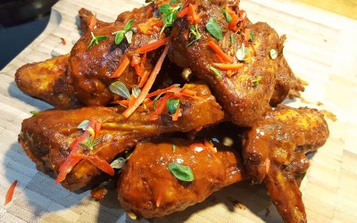 Slow smoked chicken wings tossed in hot sauce. Fresh thyme and chilli garnish