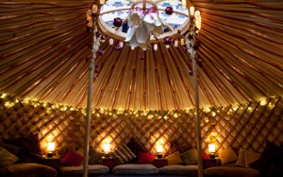 A cosy yurt with cushions, warm lighting and rugs