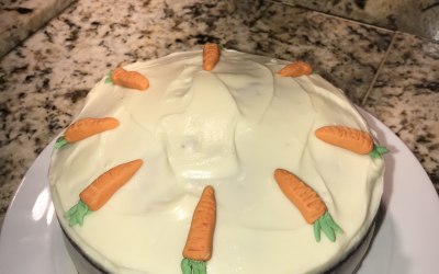 A carrot cake with sultanas and walnuts, topped with cream cheese buttercream and homemade fondant carrots.