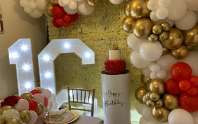 Light up numbers, flower wall, cake stand and balloon garland