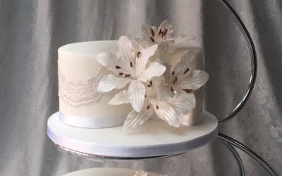 Traditional English tiered cake featuring hand crafted white lillies