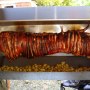 Whole Hog Roast on the spit with baby roasted potatoes, rosemary and garlic. Spit and Grill BBQ Company