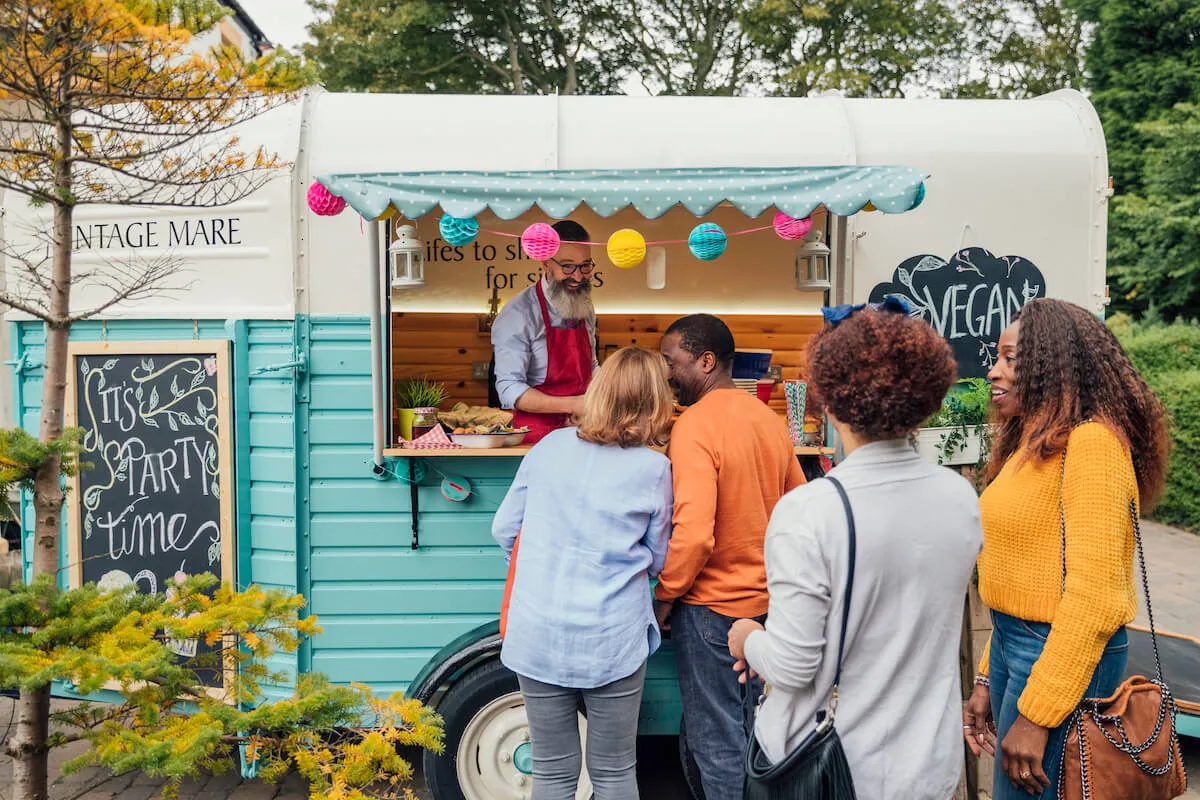 A queue of people outside a food van at an event