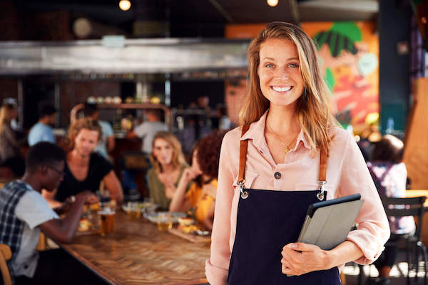 Female business owner smiling in front of customers