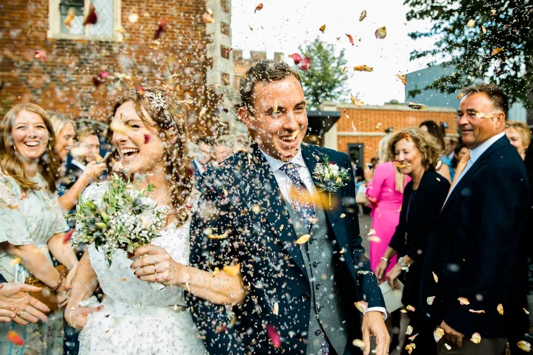 Image of wedding couple after ceremony with confetti. Image courtesy of Farlie Photography