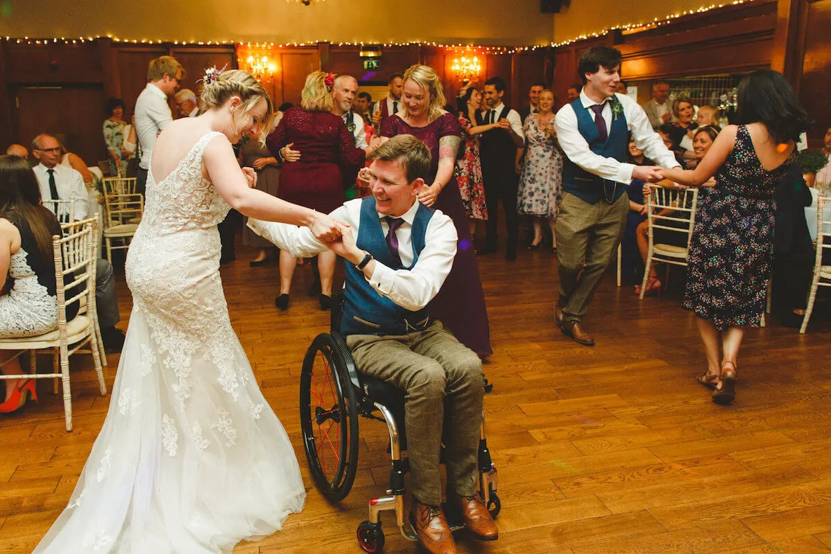 Guest in wheelchair dancing on the dance floor with other guests. Image courtesy of Camera Hannah Photography