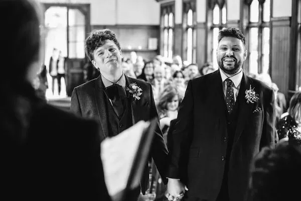 Black and white photo of homosexual couple at wedding ceremony. Image courtesy of Camera Hannah Photography