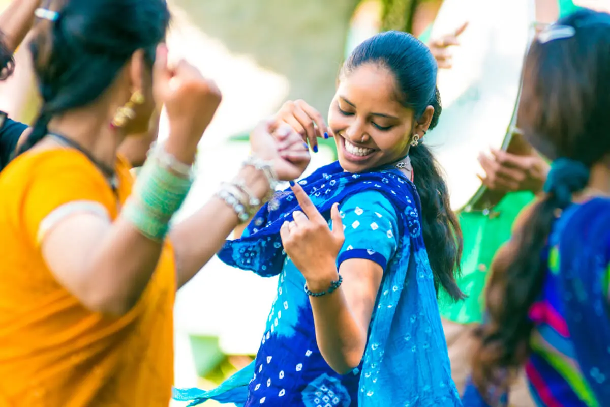 Image of indian woman wearing a blue dress and dancing with her partner