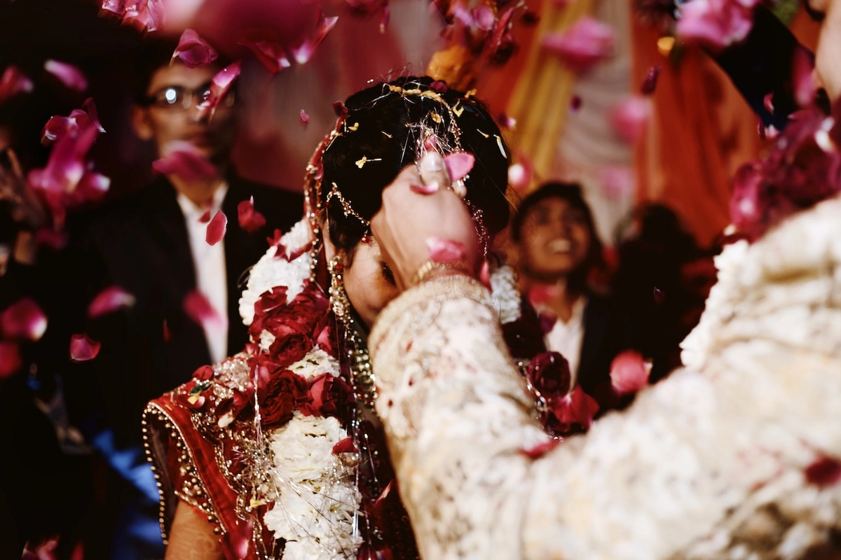 Image of indian bride and groom dancing at their wedding reception in the midst of confetti