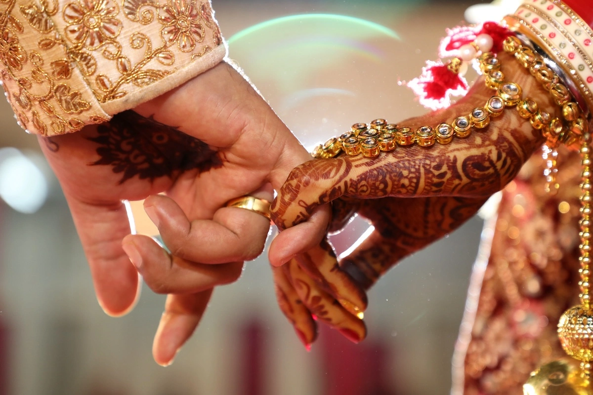 Close-up image of a couple holding hands at an indian wedding