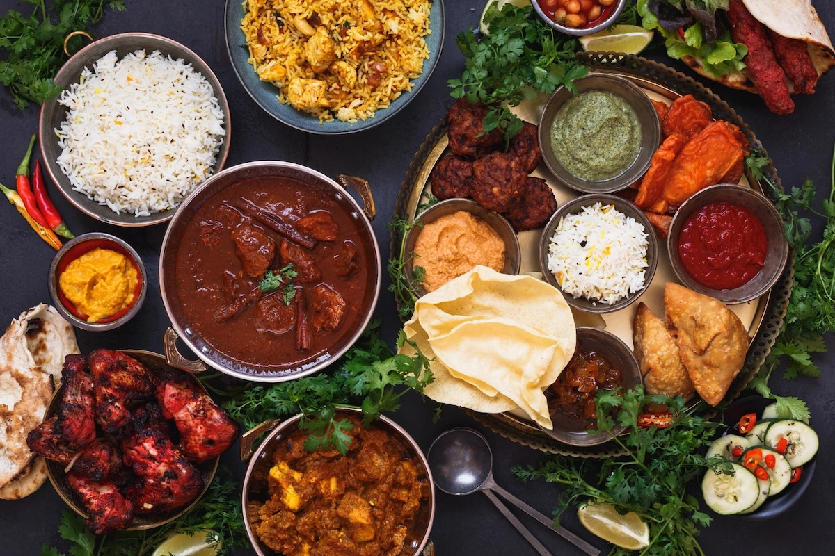 A colourful selection of indian curry and side dishes arranged on a table