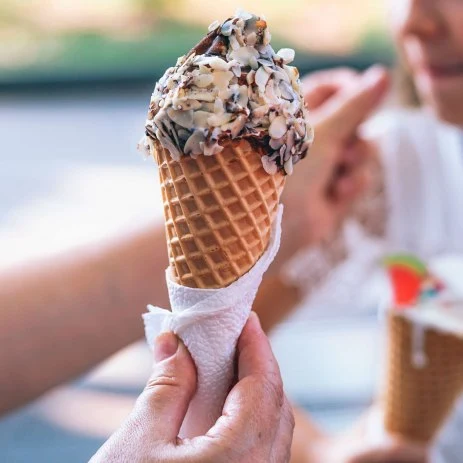 Image of a person holding a waffle cone of ice cream
