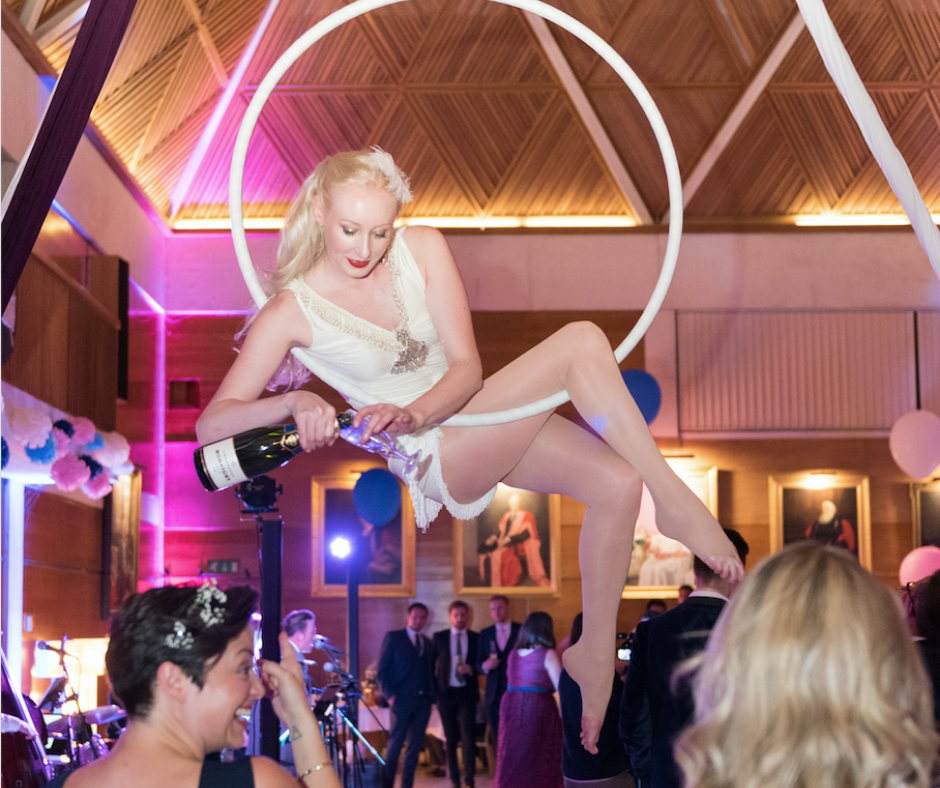 Female circus performer in ring pouring a glass of champagne