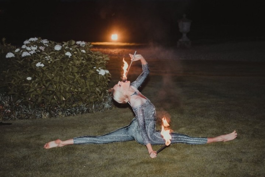 A fire eater performer doing the splits at an event