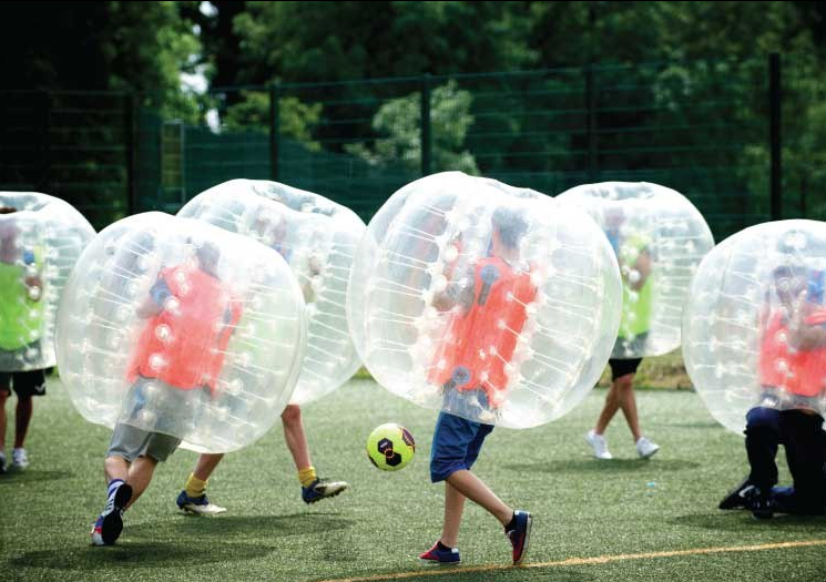 Game of bubble football on outdoor artificial pitch