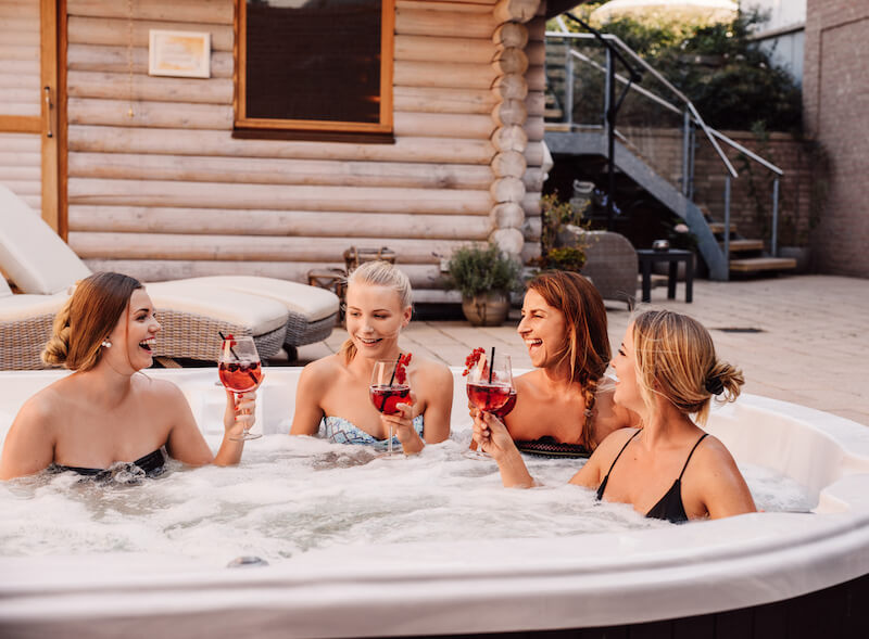 Group of women enjoying drinks in a hot tub