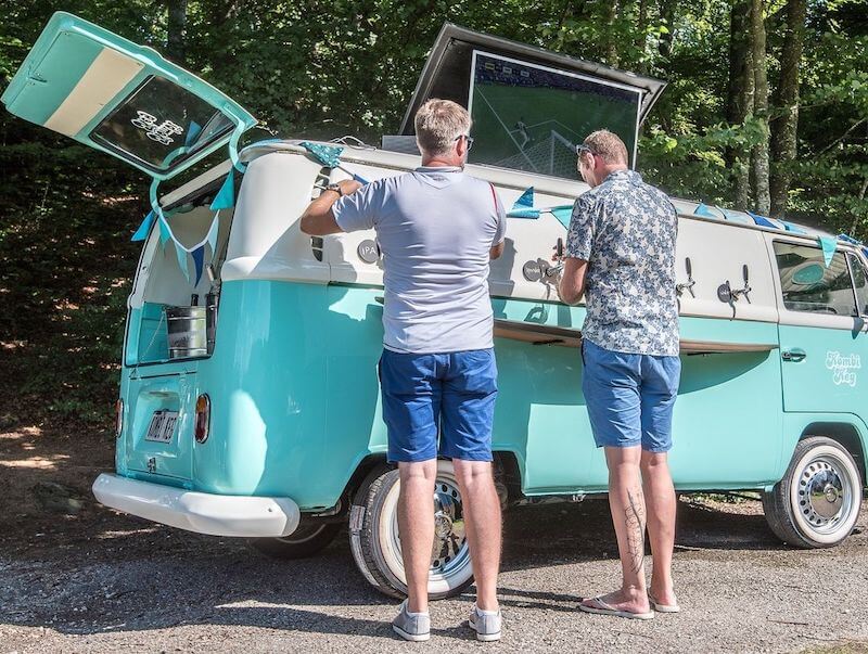 Two men pouring their own beers from the Kombi Keg van