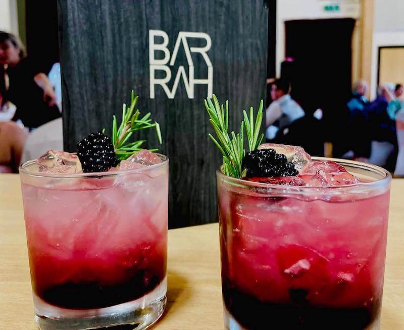 Two berry cocktails with twigs of rosemary from Bar Rah