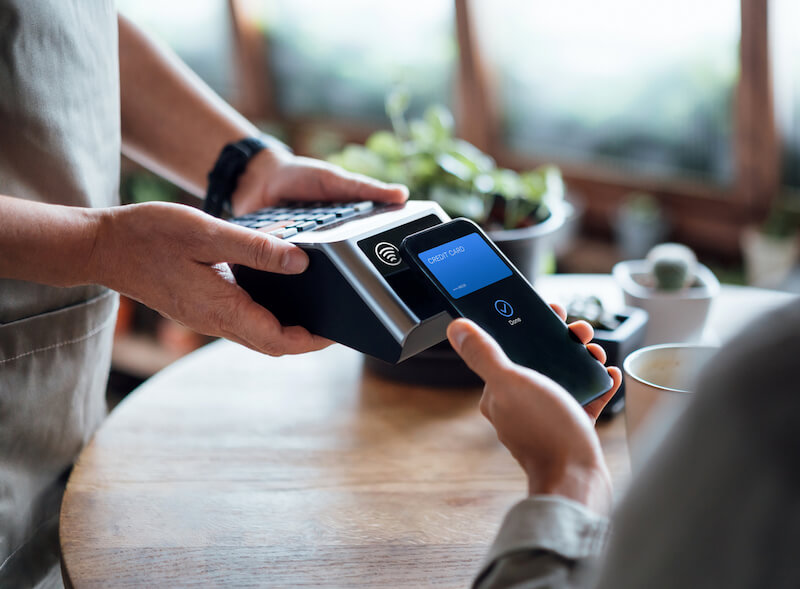Person paying for item using contactless technology via their mobile device