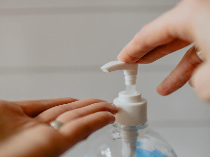 Person dispensing hand sanitiser into their hand