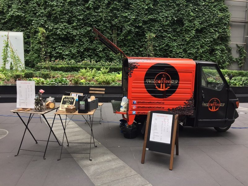 Mini three-wheeler Coffee Cup van serving coffee in the city