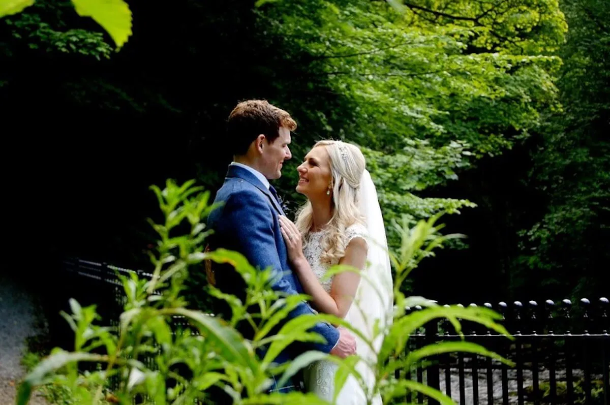 A newly wedded couple posing for photos surrounded by green plants