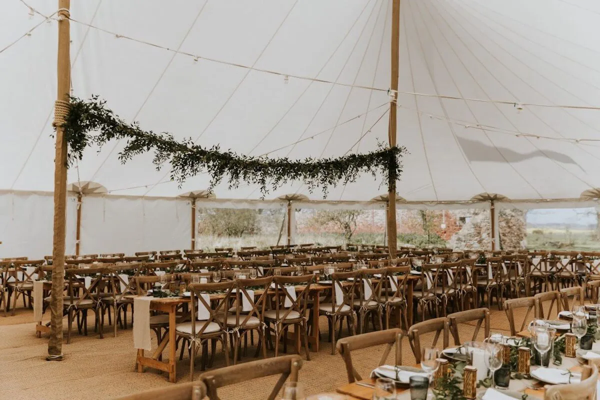 Rustic wedding table decorations inside large stretch marquee