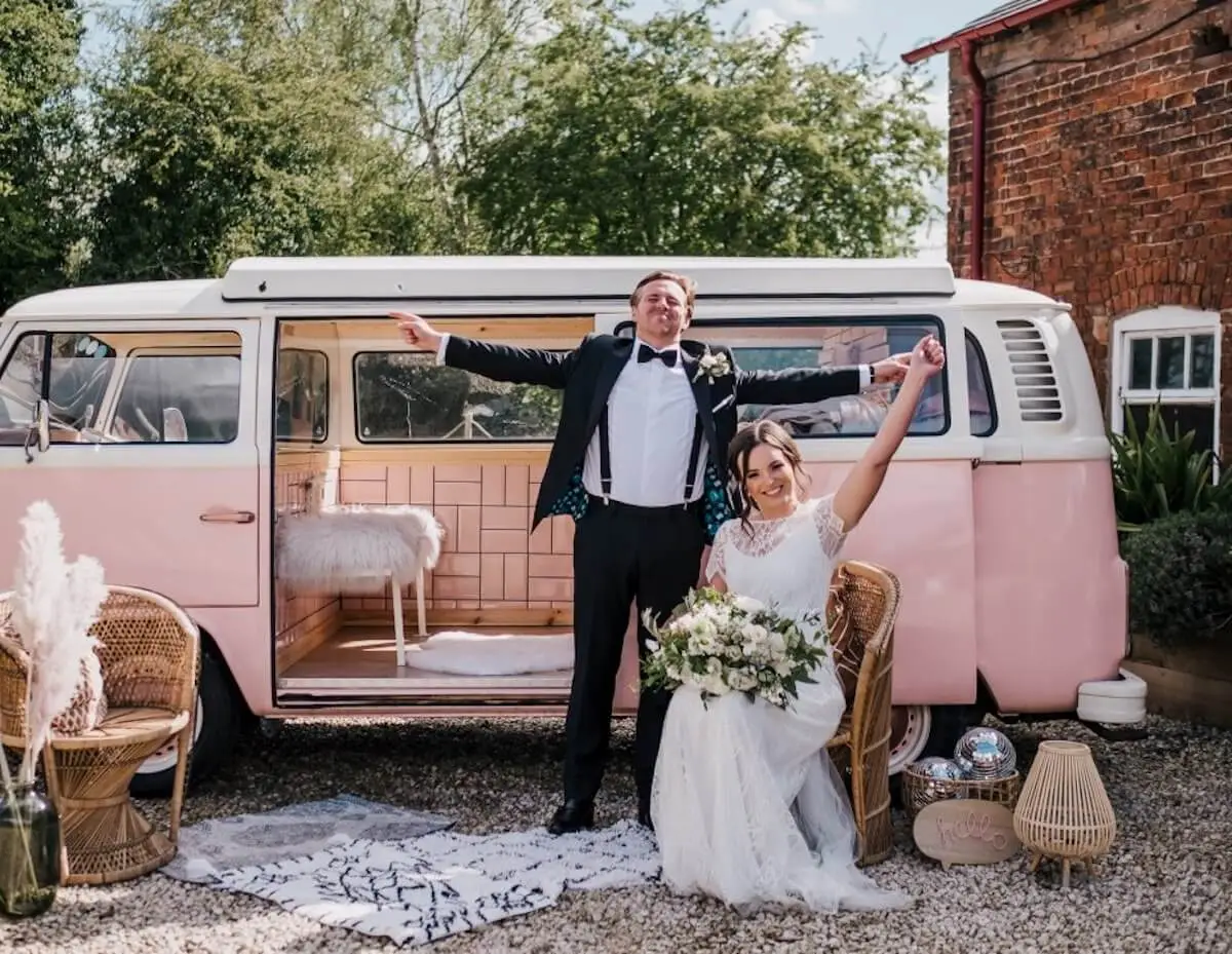 Bride and groom getting photo in front of converted VW camper van photo booth