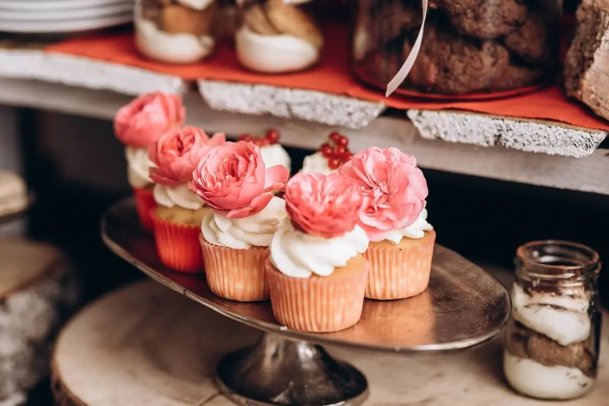 Half a dozen wedding cupcakes with pink roses as decorations