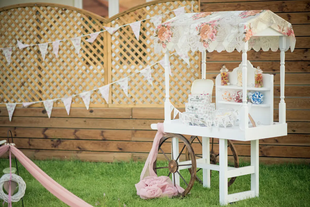 Image of white candy buffet set up at an outdoor wedding