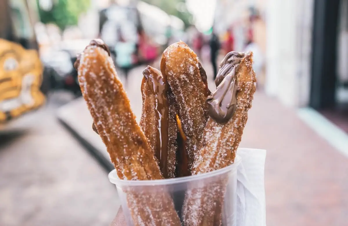 Up close image of 4 churros in take-away cup at wedding