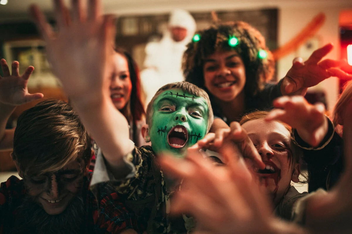 A group of children with spooky halloween face paint enjoying a halloween party