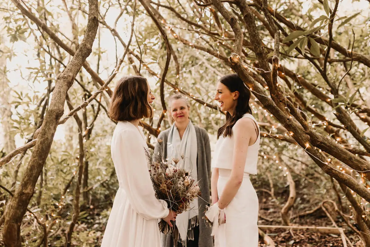 A female couple getting married in a whimsical forest