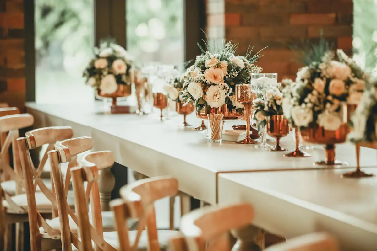 Contemporary and clean wedding table decorations with flower bunches and copper ornaments