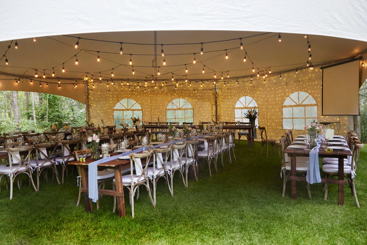 Wedding tables underneath a large marquee tent in festival setting