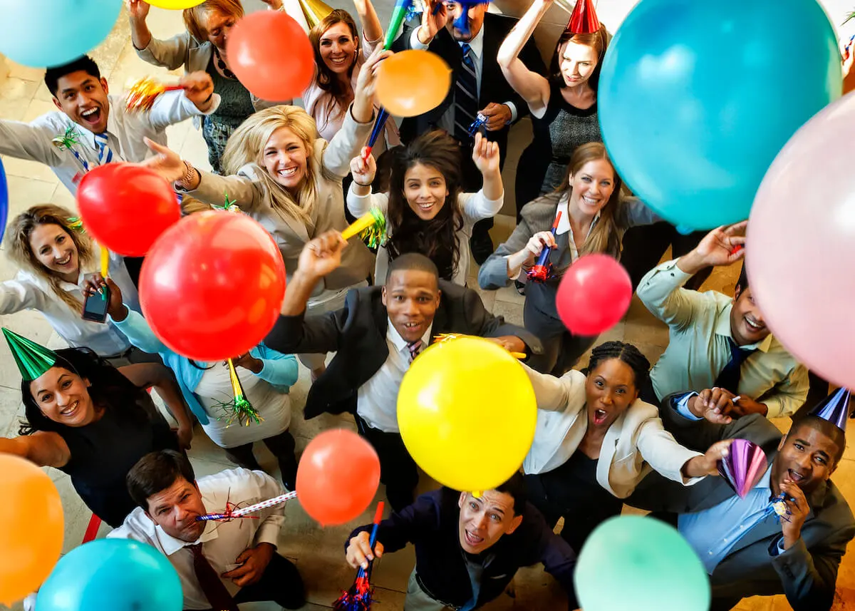 Group of colleagues at a work party with colourful balloons