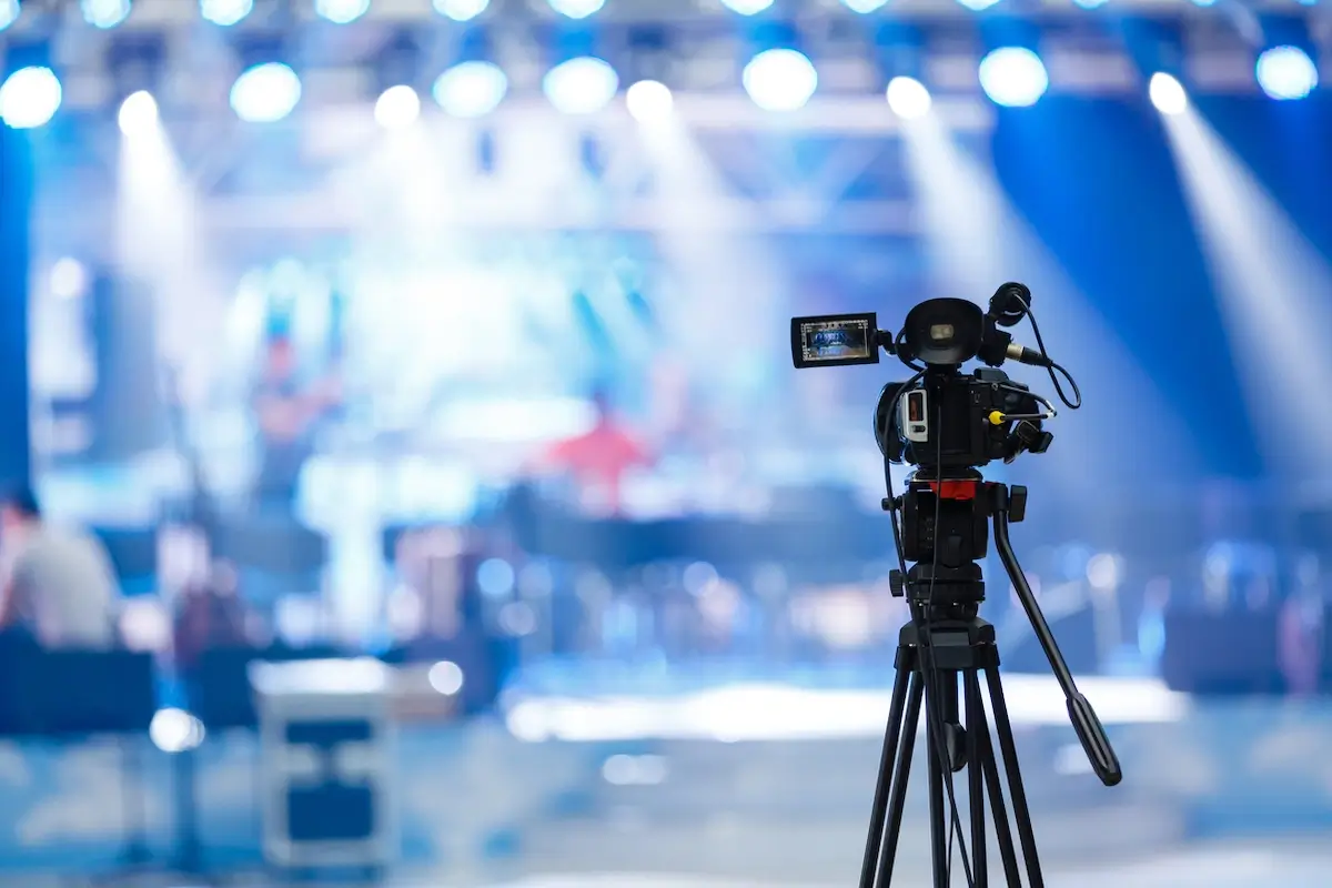 Video camera recording an event with a stage in the background