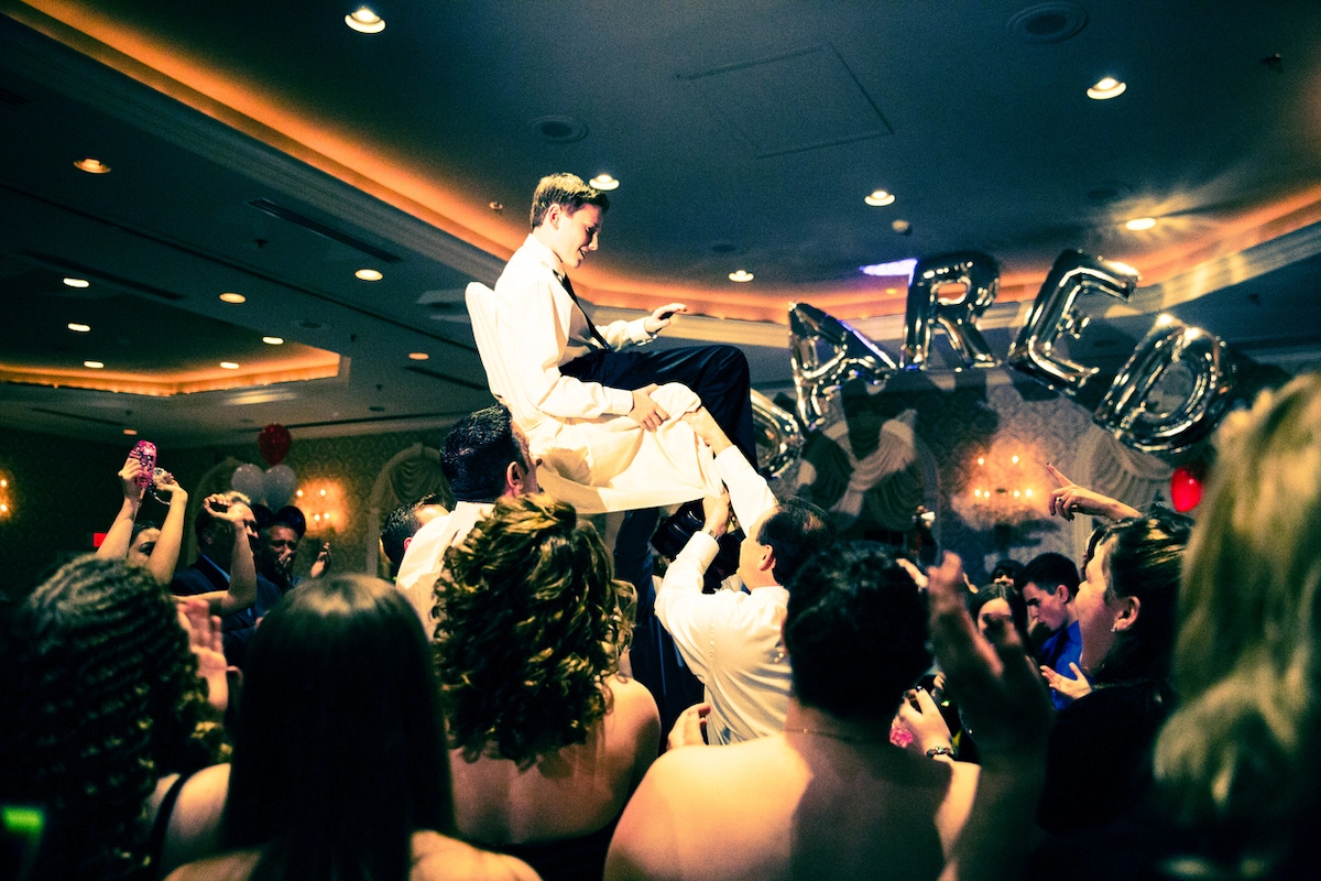 Young boy is held up on a chair for his bar mitzvah celebrations