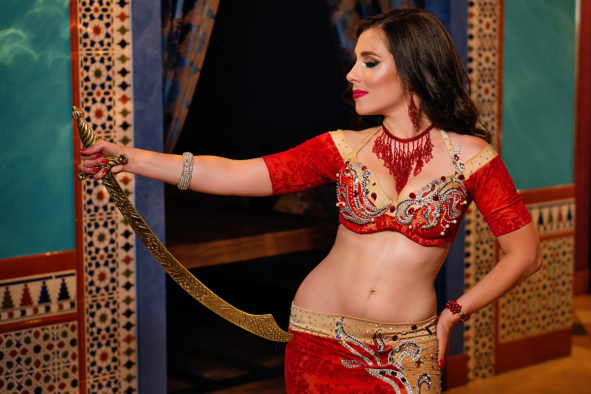 An arabian belly dancer posing with a sword