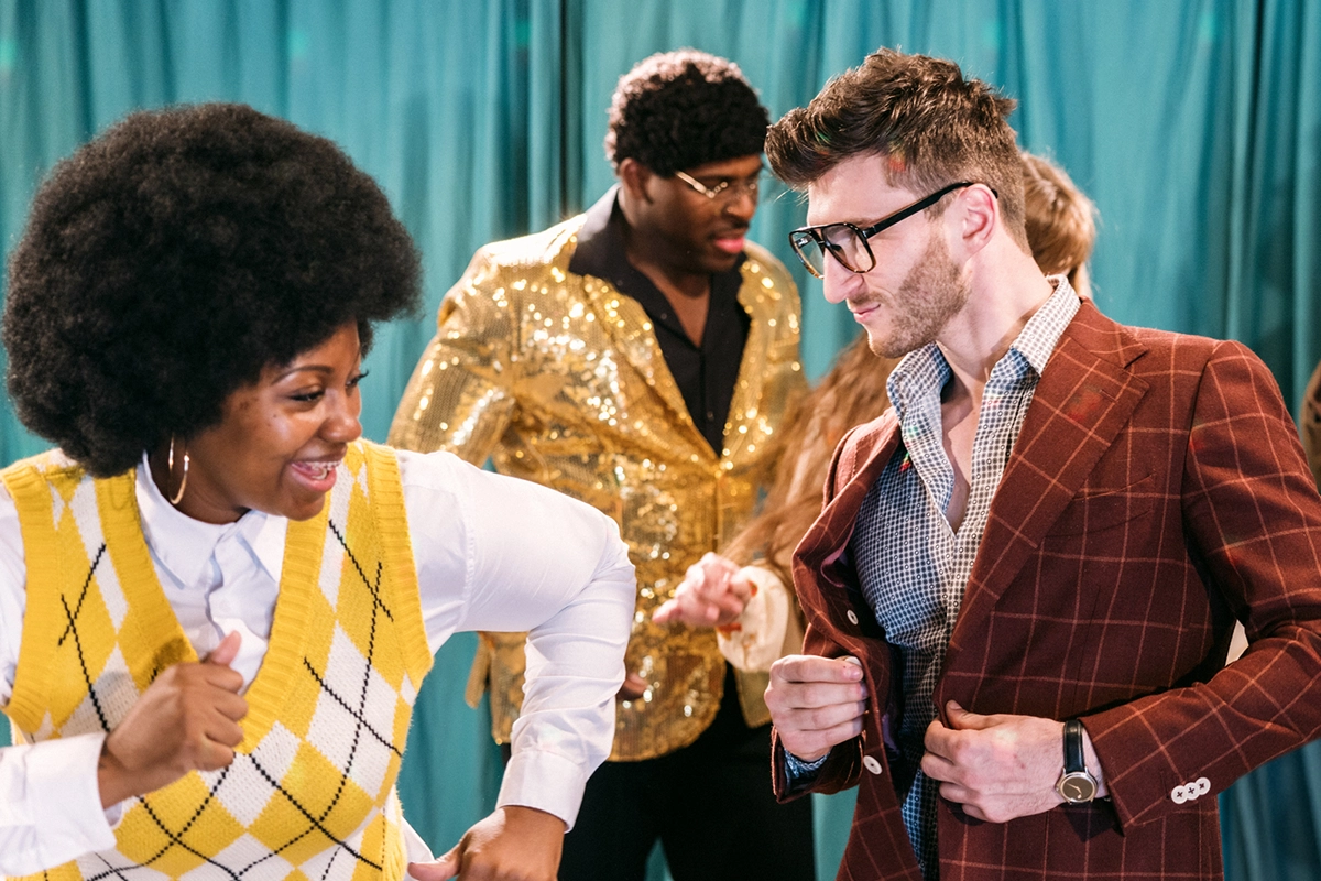 A group of people dressed in 80s retro style dancing