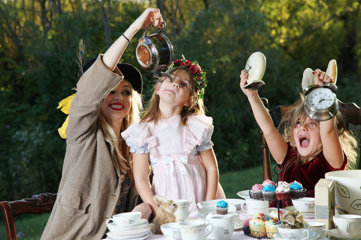 Two young girls and a woman at an alice in wonderland themed tea party