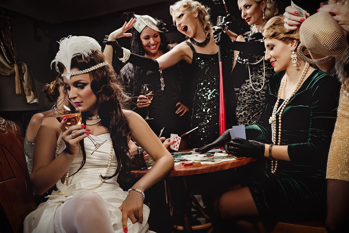 A group of young women wearing the 1920s style dresses and playing card games